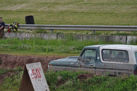 1979 Ford Bronco - A 1979 Ford Bronco is partially submerged in mud, with a '50' marker visible in the foreground.