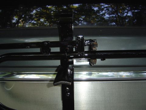 1986 Ford Bronco - Close-up of a spare tire carrier mechanism on a vehicle's rear.