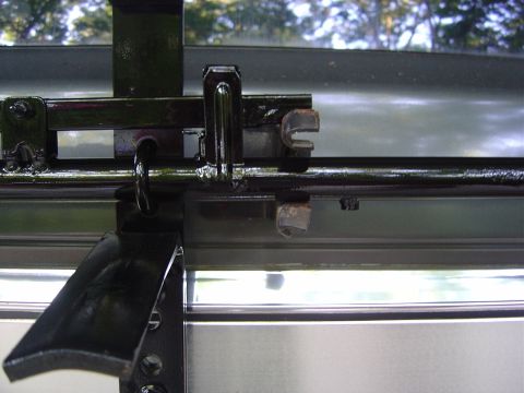 1986 Ford Bronco - Close-up of a spare tire carrier latch mechanism, likely from an older SUV.