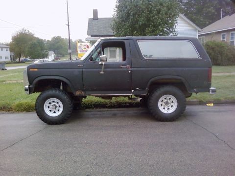 1986 Ford Bronco - This black Ford Bronco appears to be from the early 1980s, with a lifted suspension and white wheels.