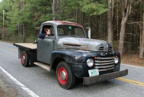 1974 Ford Bronco - This 1948 Ford F-series flatbed truck is being driven on a road.
