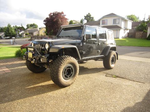 2008 Jeep Wrangler - Modified black Jeep Wrangler parked in a driveway.