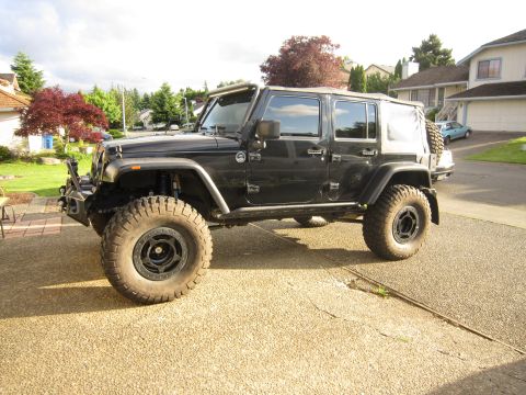 2008 Jeep Wrangler - This modified Jeep Wrangler features aftermarket fenders and aggressive off-road tires, suggesting it's built for terrain.