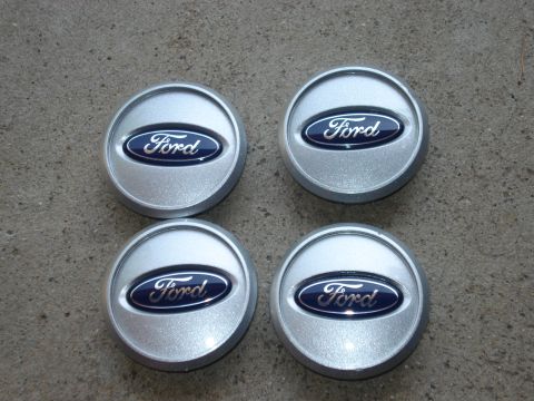 2000 Ford Crown Victoria - A set of four Ford center caps is displayed on a textured gray surface.