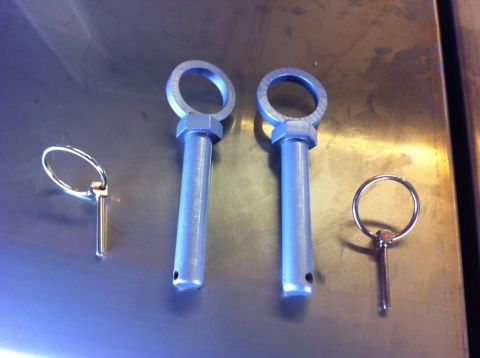 1987 Suzuki Samurai - Four hitch pins are laid out on a metallic surface, with two larger pins in the center.