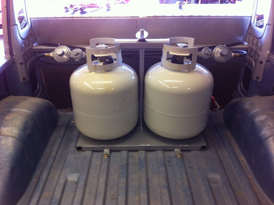 Two propane tanks mounted in the bed of a pickup truck