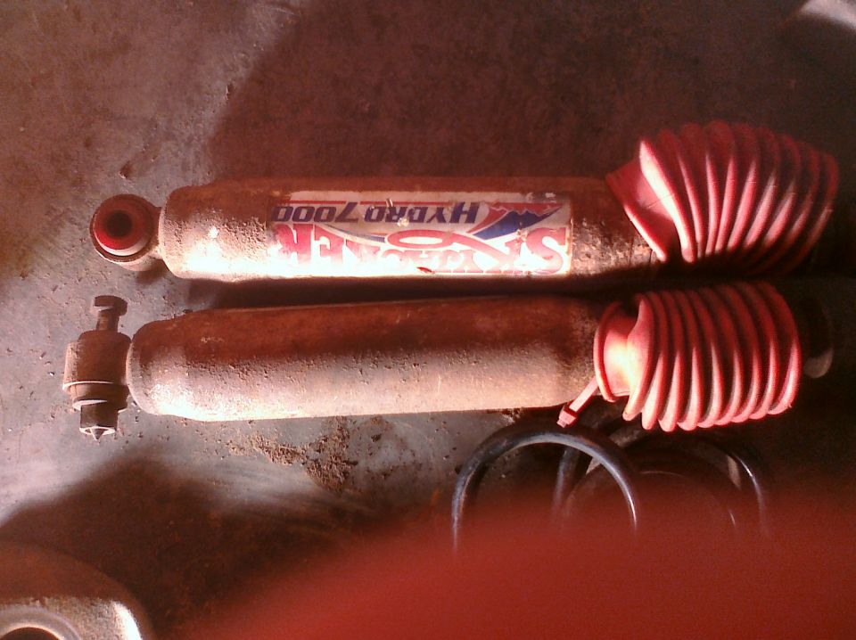 Two old shock absorbers, one with a "Sachs Hydro 7000" sticker