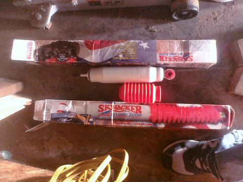 1995 Ford Bronco - Two Skyjacker shock absorbers are shown, one in its original packaging with red and white graphics.