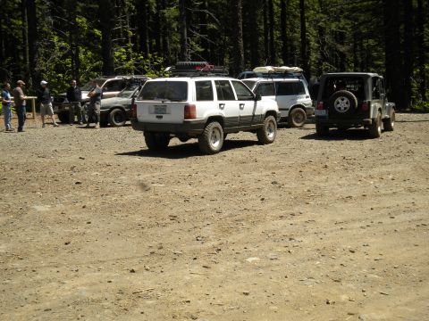2005 Jeep Wrangler - Group of off-road vehicles gathered in a forest clearing.