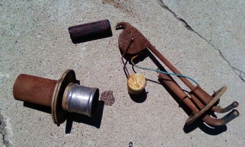 2006 Ford E350 - Fuel pump and sender assembly disassembled and laid out on a concrete surface.