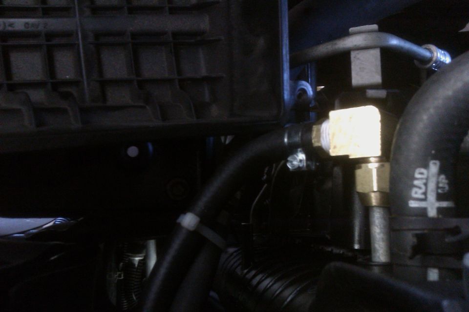 Close-up of brass fittings and hoses in an engine bay