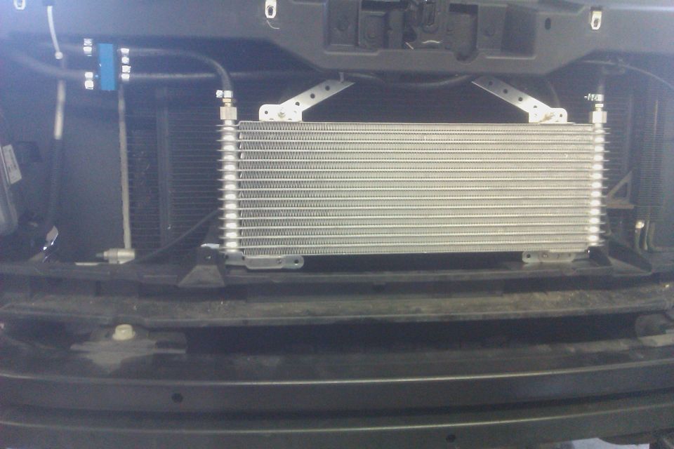 Transmission cooler mounted in front of radiator, with hoses and fittings
