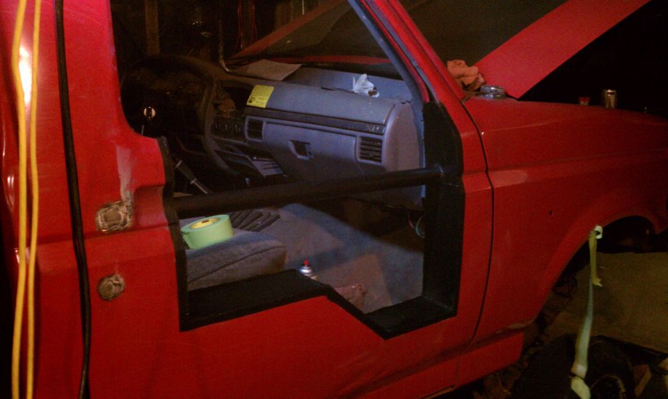 Red truck interior with door removed, showing dashboard and seat. 1994 Ford F-250