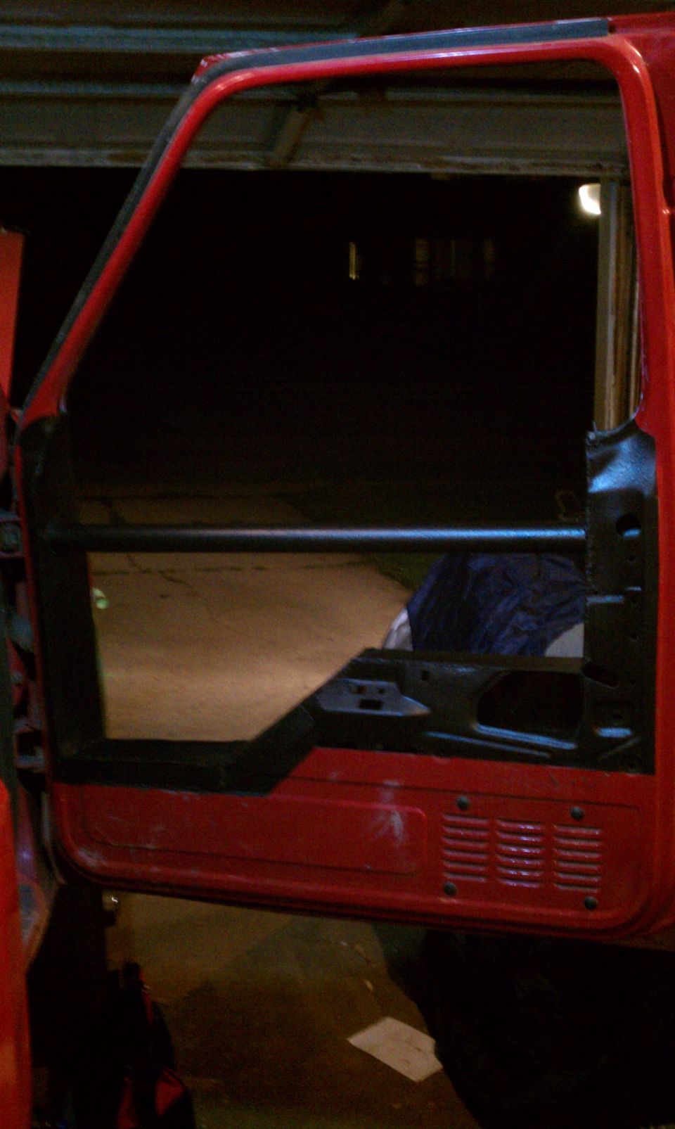 red truck door frame, open, showing interior structure and a dark interior space