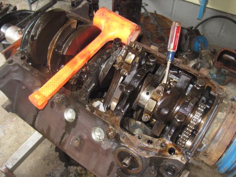 1979 Ford Bronco - Close-up view of an engine block's internal components, including the crankshaft and connecting rods, with tools present.