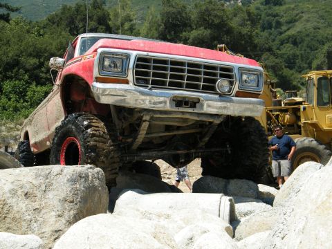 1982 Ford Bronco - Modified 1979 Ford F-Series truck tackling a rocky trail, with a yellow loader nearby.