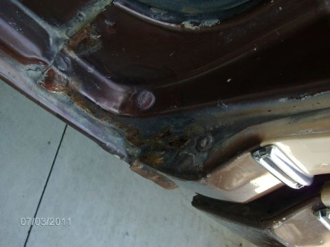 1979 Ford F-150 - Close-up of a heavily rusted door jamb on a brown vehicle, showing extensive corrosion and damage.