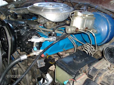 1979 Ford F-150 - Close-up view of an engine bay, highlighting the air conditioning compressor and blue valve cover.