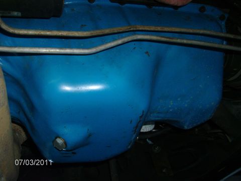 1979 Ford F-150 - Close-up view of a blue painted engine oil pan with metal lines running overhead.