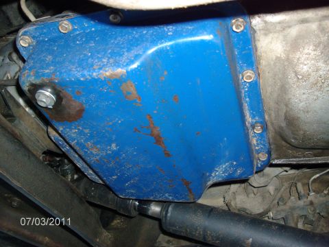 1979 Ford F-150 - Close-up of a blue oil pan on a vehicle's underside, showing some wear and tear.