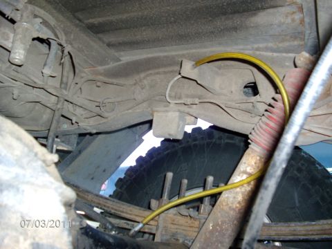 1979 Ford F-150 - Undercarriage view of a truck, showing suspension components and a yellow brake line. Date stamp visible.