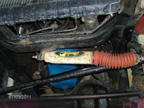 1979 Ford F-150 - Close-up view of a Superlift steering stabilizer and associated suspension components on a vehicle.