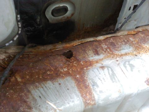 2000 Ford Crown Victoria - Severe rust damage visible on the undercarriage of a vehicle.