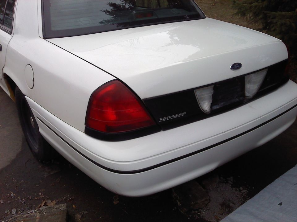 White Ford Crown Victoria rear, showing taillight, trunk, and "POLICE INTERCEPTOR" text
