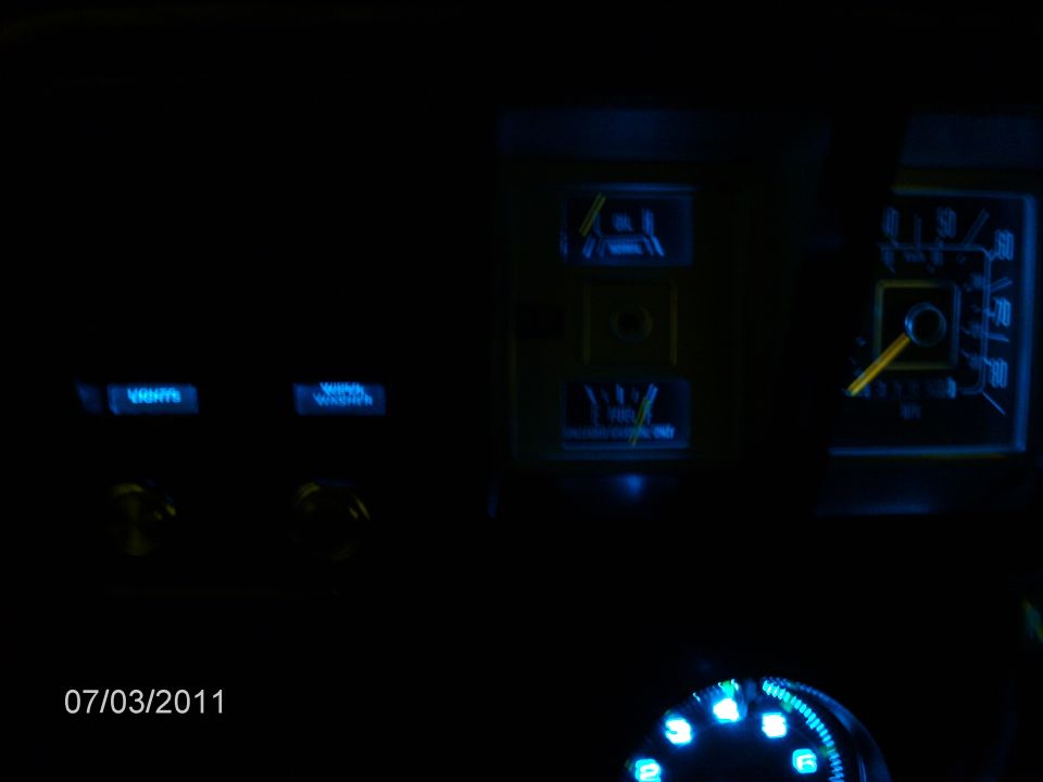 Dashboard gauges with blue LED lighting, showing a speedometer and other indicators. Date stamp 07/03/2011