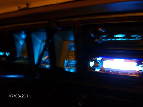 1979 Ford F-150 - Interior view of a vehicle's dashboard at night, showing blue dash lights and car audio equipment.
