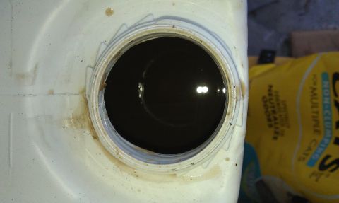 1992 Ford Ranger - The photo shows a close-up view of a white plastic container with a dark liquid inside, likely an oil reservoir.