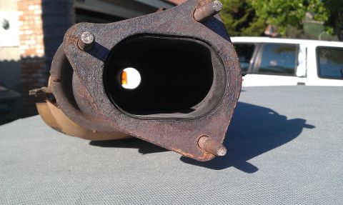 1992 Ford Ranger - Close-up of a rusty exhaust manifold flange, showing the opening for exhaust gases and three mounting studs.