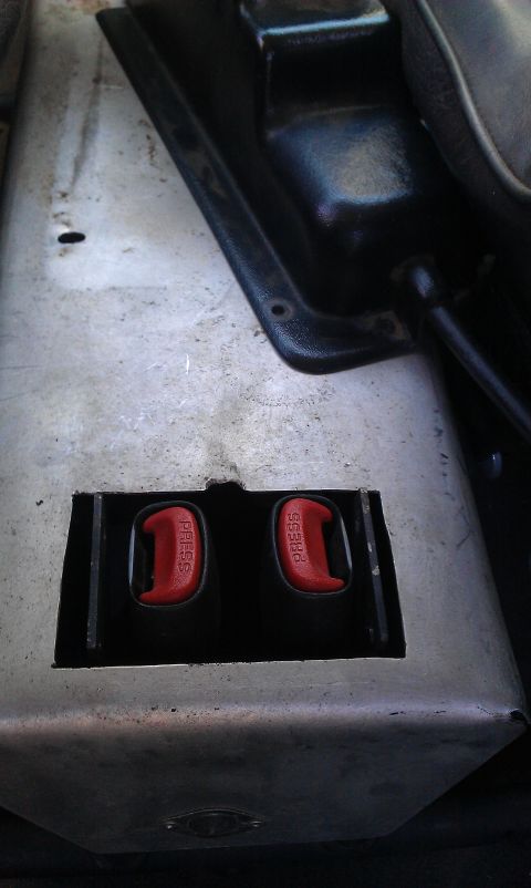 1992 Ford Ranger - Close-up of two red seat belt buckles, each marked with 'PRESS'.
