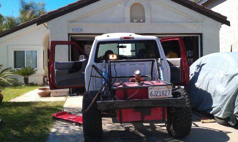 1992 Ford Ranger - A modified pickup truck is parked in a driveway with its doors open, showing a custom fuel tank and roll cage.