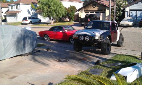 1992 Ford Ranger - A heavily modified pickup truck sits in a driveway next to a red convertible and other vehicles.