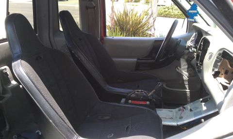 1992 Ford Ranger - The interior of a red truck shows racing seats and a dashboard that has been removed, with a "Supermotors" watermark in the corner.