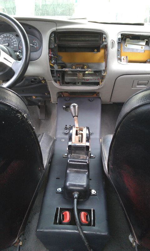 1992 Ford Ranger - The dashboard and center console of a vehicle are shown with components removed, revealing wiring and the gear shifter.