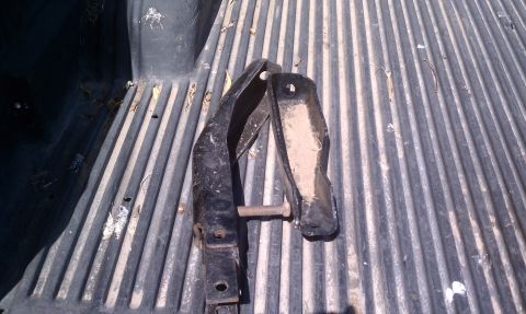 1979 Ford Bronco - Metal brackets and bolt on a ribbed truck bed surface.