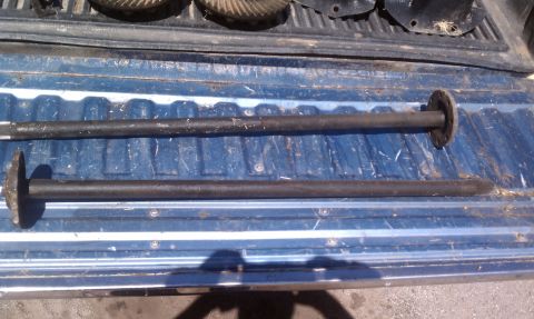 1979 Ford Bronco - Two axles with flanges are pictured in a truck bed, likely for sale.
