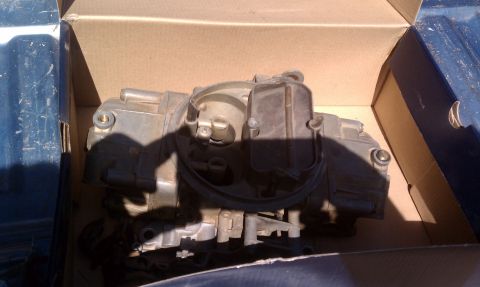 1979 Ford Bronco - A close-up view of a carburetor, a key component of an internal combustion engine.