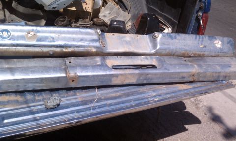 1979 Ford Bronco - Chrome bumpers are piled in the back of a truck, with one bearing an 'AMA' logo.