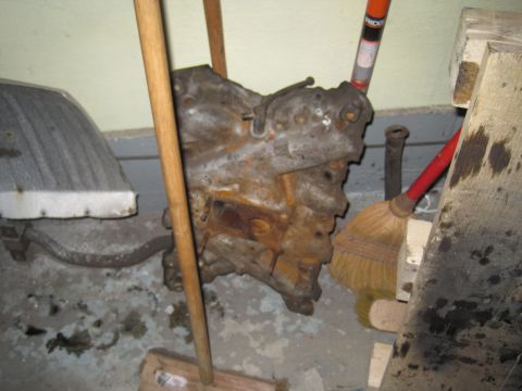 1979 Ford Bronco - A heavily corroded engine block is stored indoors with cleaning tools.