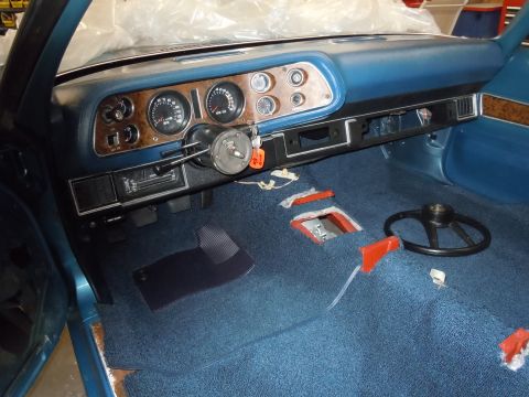 1972 Chevrolet Camaro - The interior of a 1972 Chevrolet Camaro shows blue carpeting and wood grain accents on the dashboard.