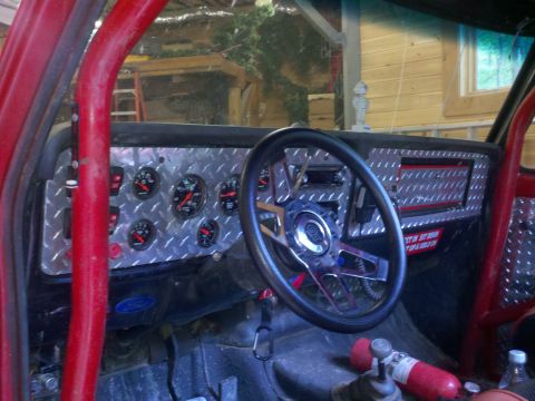 1979 Ford Bronco - The interior features a custom dashboard with numerous gauges and a roll cage, suggesting a modified vehicle.