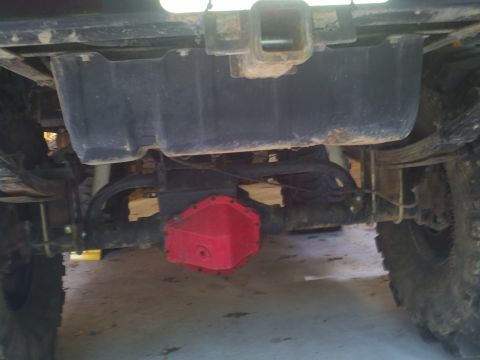 1979 Ford Bronco - Close-up view of a red aftermarket differential cover installed on a vehicle's rear axle.