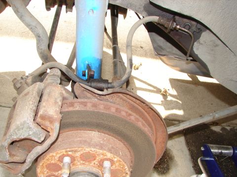 1992 Ford Taurus - This photo shows a car's brake assembly, including the rotor, caliper, and shock absorber.