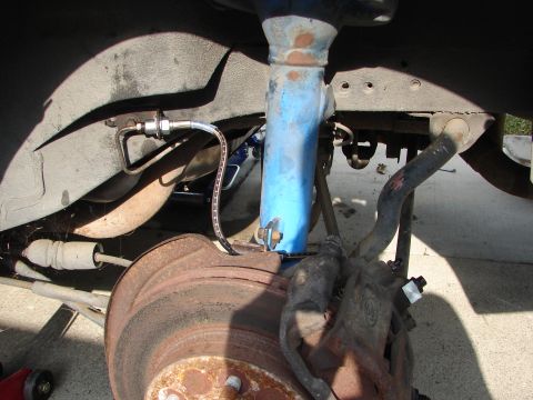 1992 Ford Taurus - Close-up of a car's brake system, showing a rusty rotor and brake caliper.