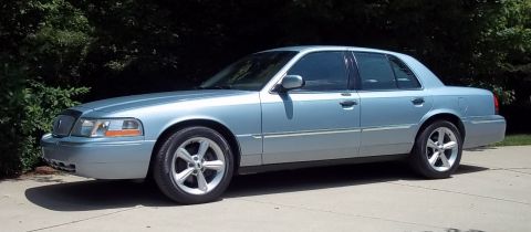 2003 Mercury Grand Marquis - A light blue 2003 Mercury Grand Marquis sedan is shown from a three-quarter front angle.