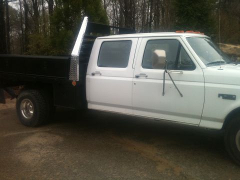 1997 Ford F-350 - Side view of a white 1997 Ford F-350 crew cab truck with a flatbed.