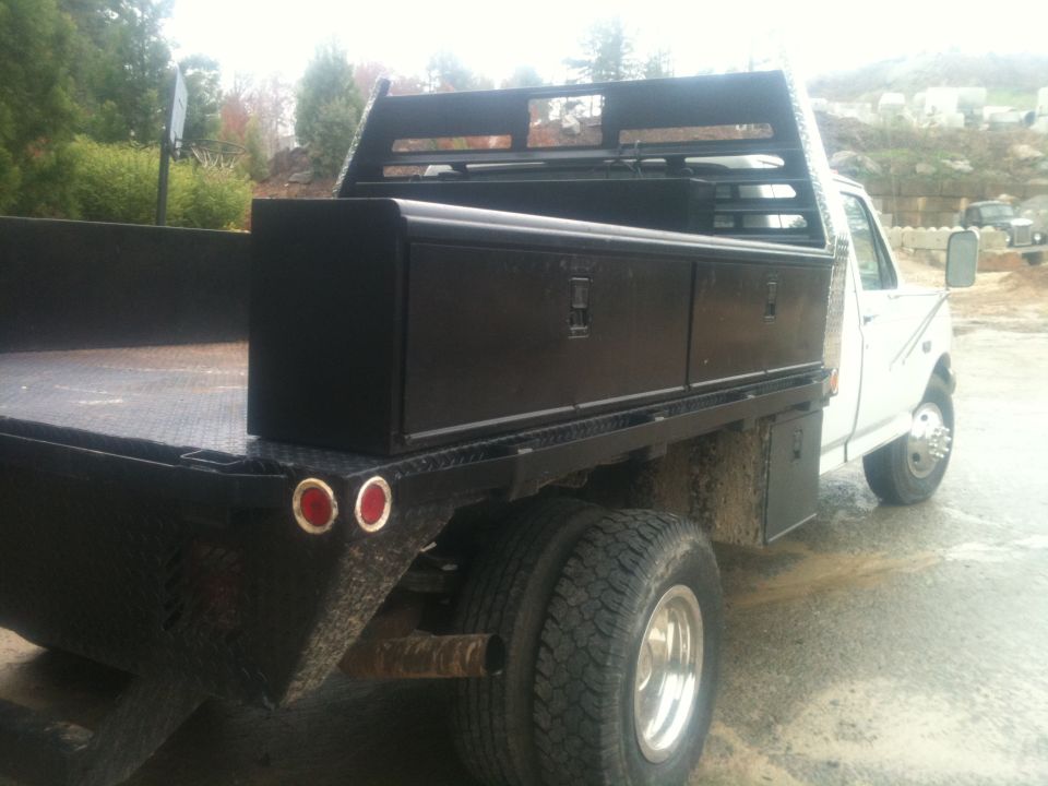 White 1997 Ford F-350 flatbed truck with dual rear wheels and black toolboxes